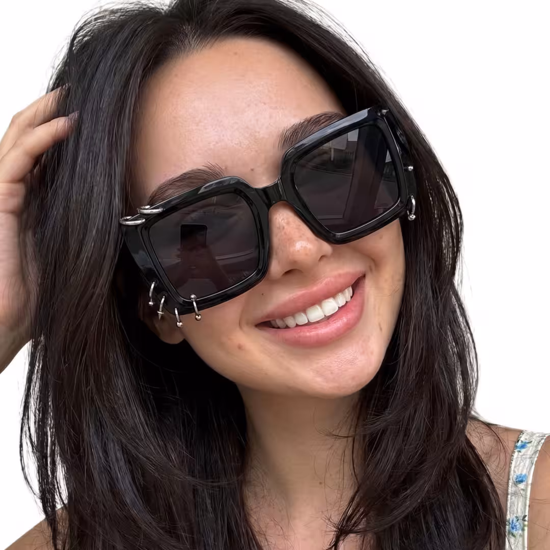 Tilted head view of female wearing black square sunglasses, hand in hair, natural smile, SR0052509