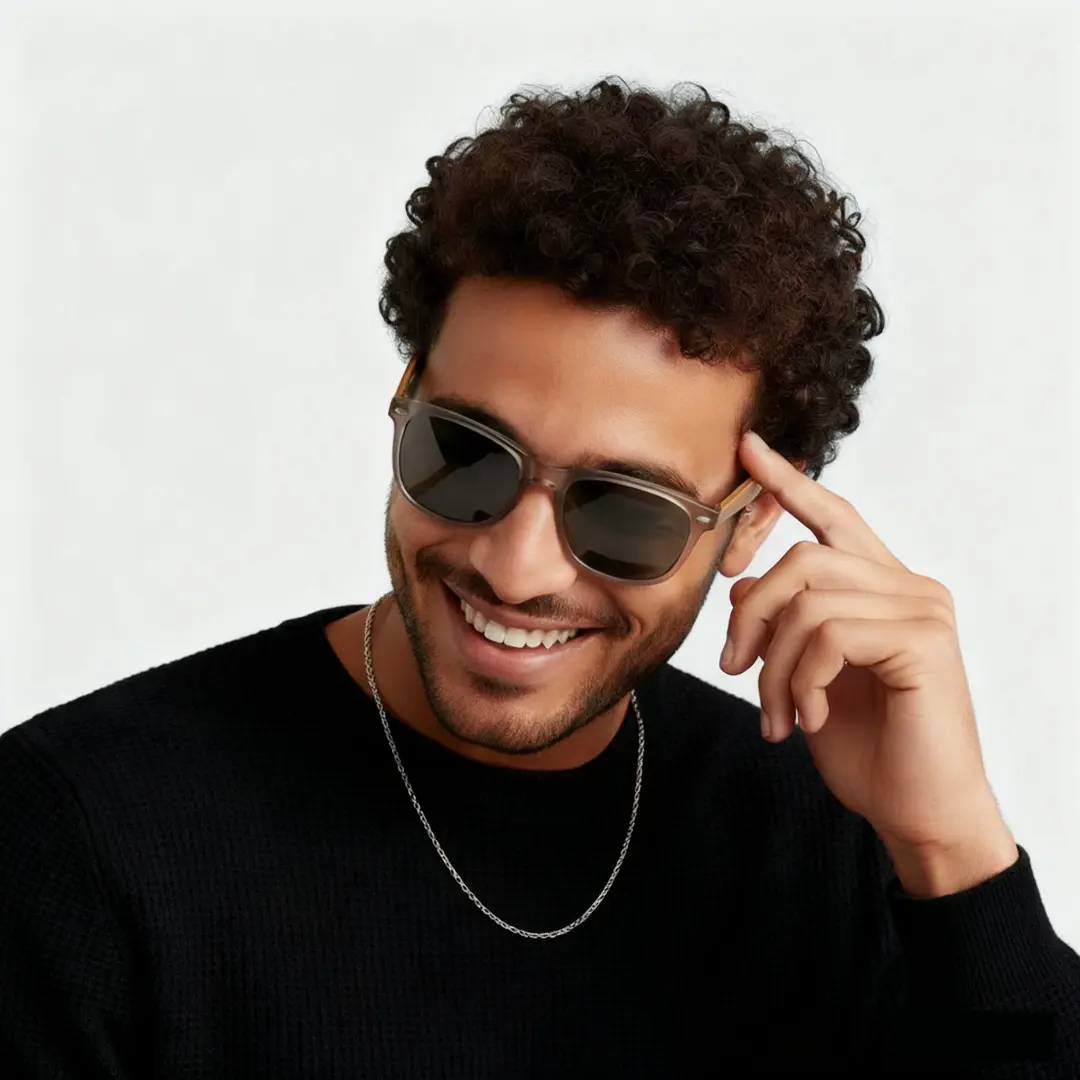 Three-quarter view of male wearing grey square sunglasses, hand in hair, smiling, SR0182303