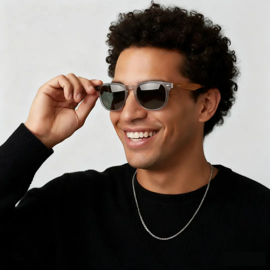 Three-quarter view of male wearing grey square sunglasses, touching frame, smiling, SR0182303