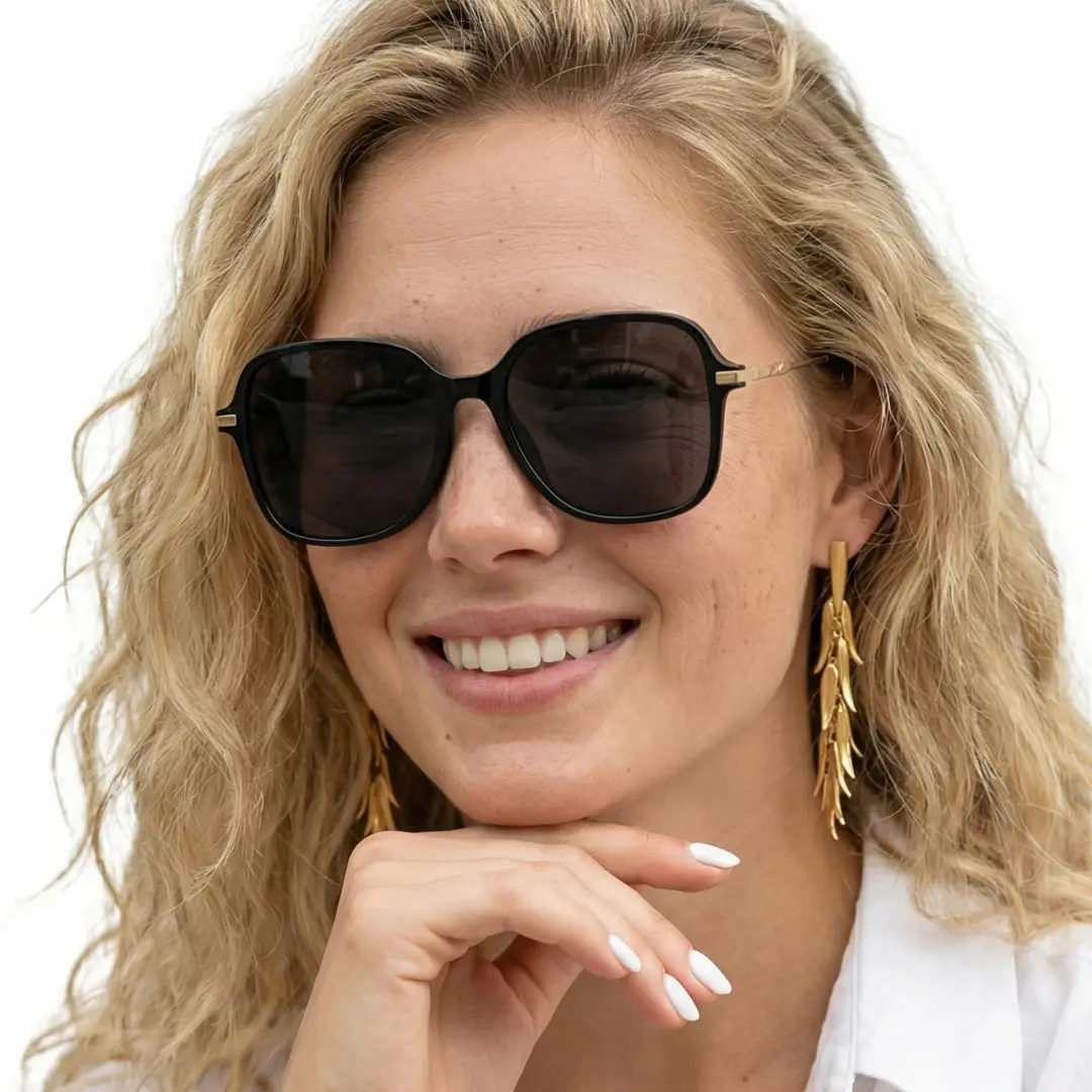 Front view of female wearing black square sunglasses, resting chin on hand, smiling, SR0222410