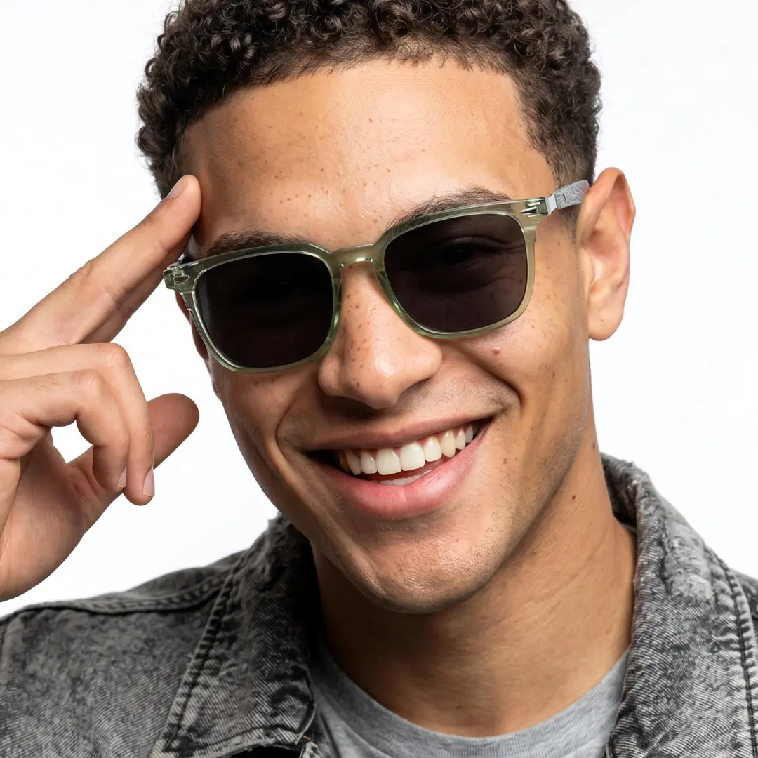 Front view of male wearing green square sunglasses, hand resting on forehead, natural smile, SR0232410