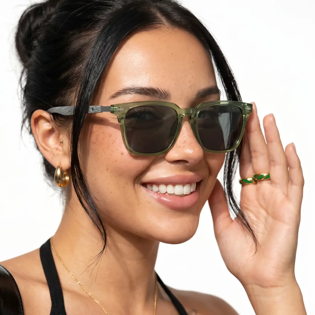 Profile view of female wearing green square sunglasses, hand near face, smiling, SR0232410