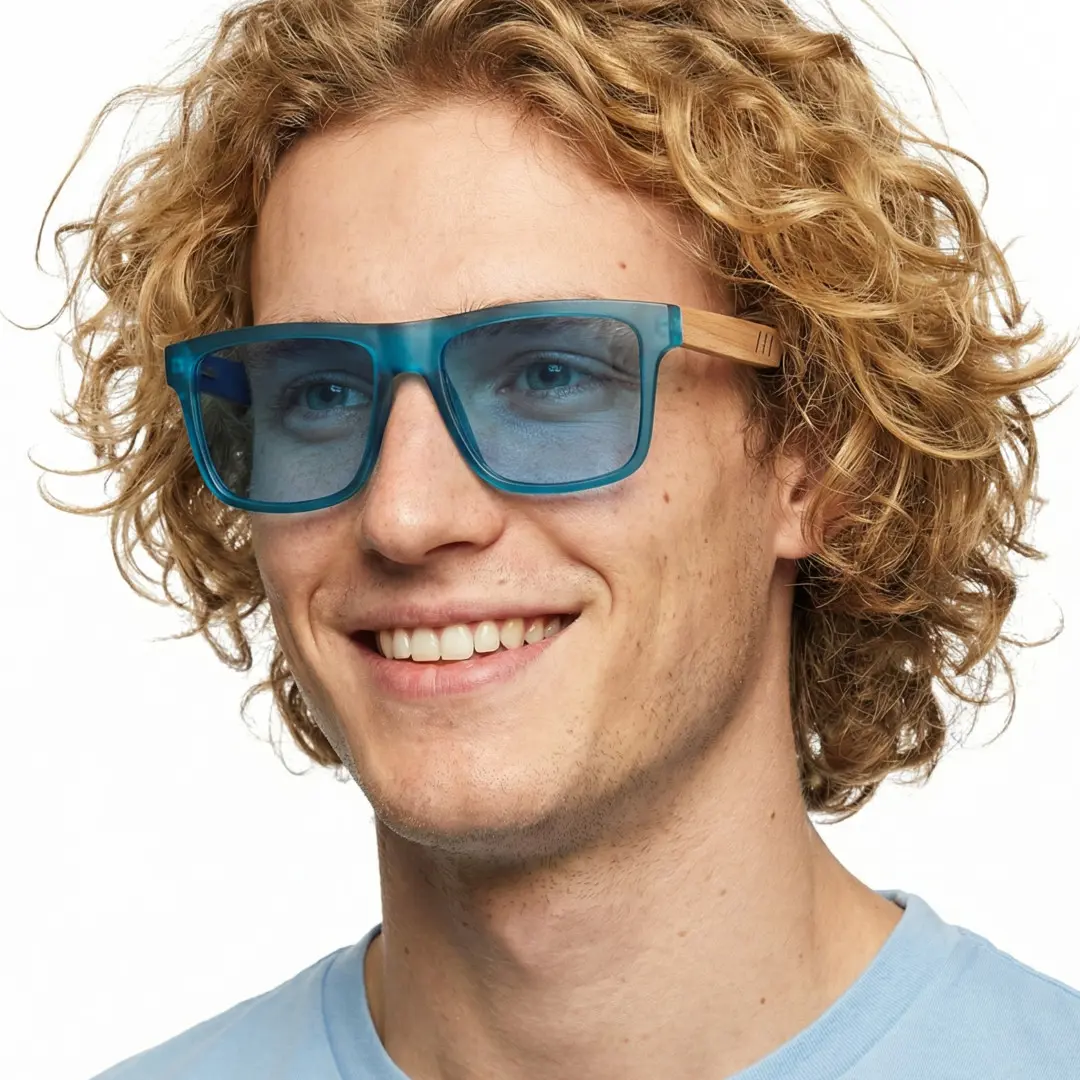 Profile view of male wearing blue square sunglasses, smiling, SX0012304