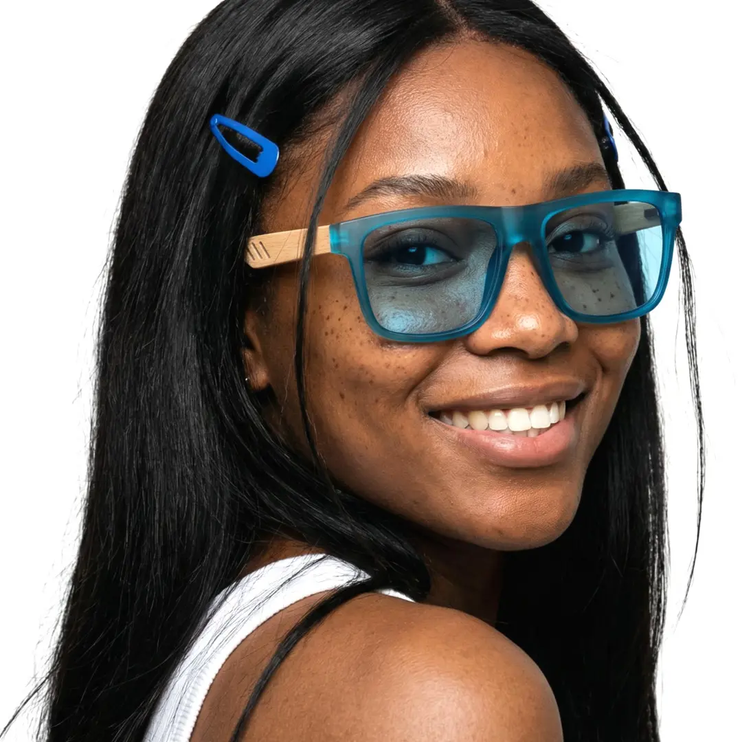 Over-the-shoulder view of female wearing blue square sunglasses, smiling, SX0012304