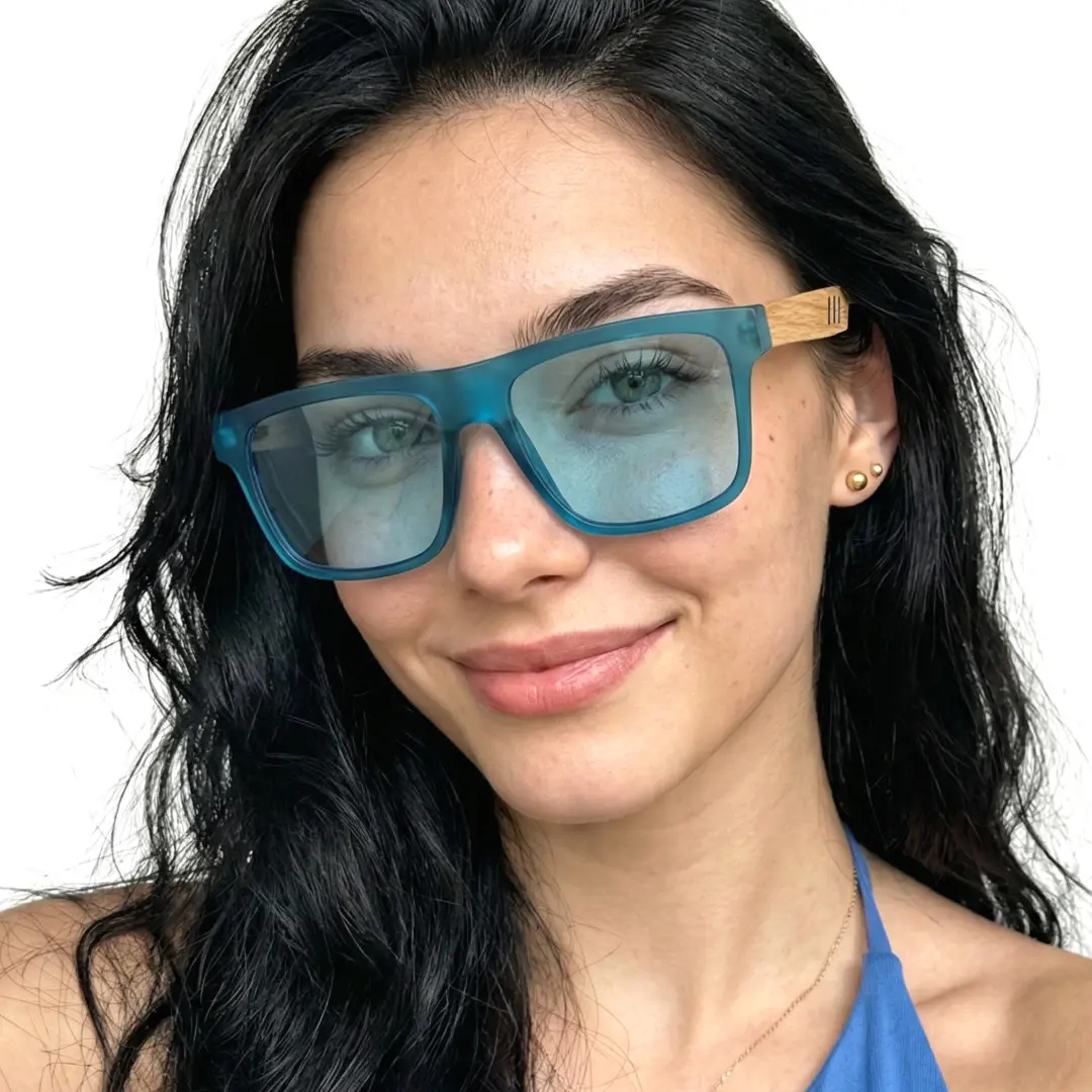 Slightly angled view of female wearing blue square sunglasses, soft smile, SX0012304