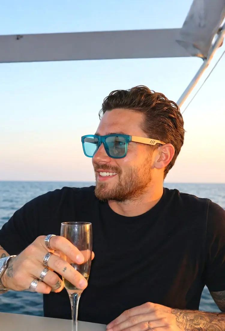 Male model wearing everyday blue square wood sunglasses outdoors on a boat at sunset. SPU: SX0012304