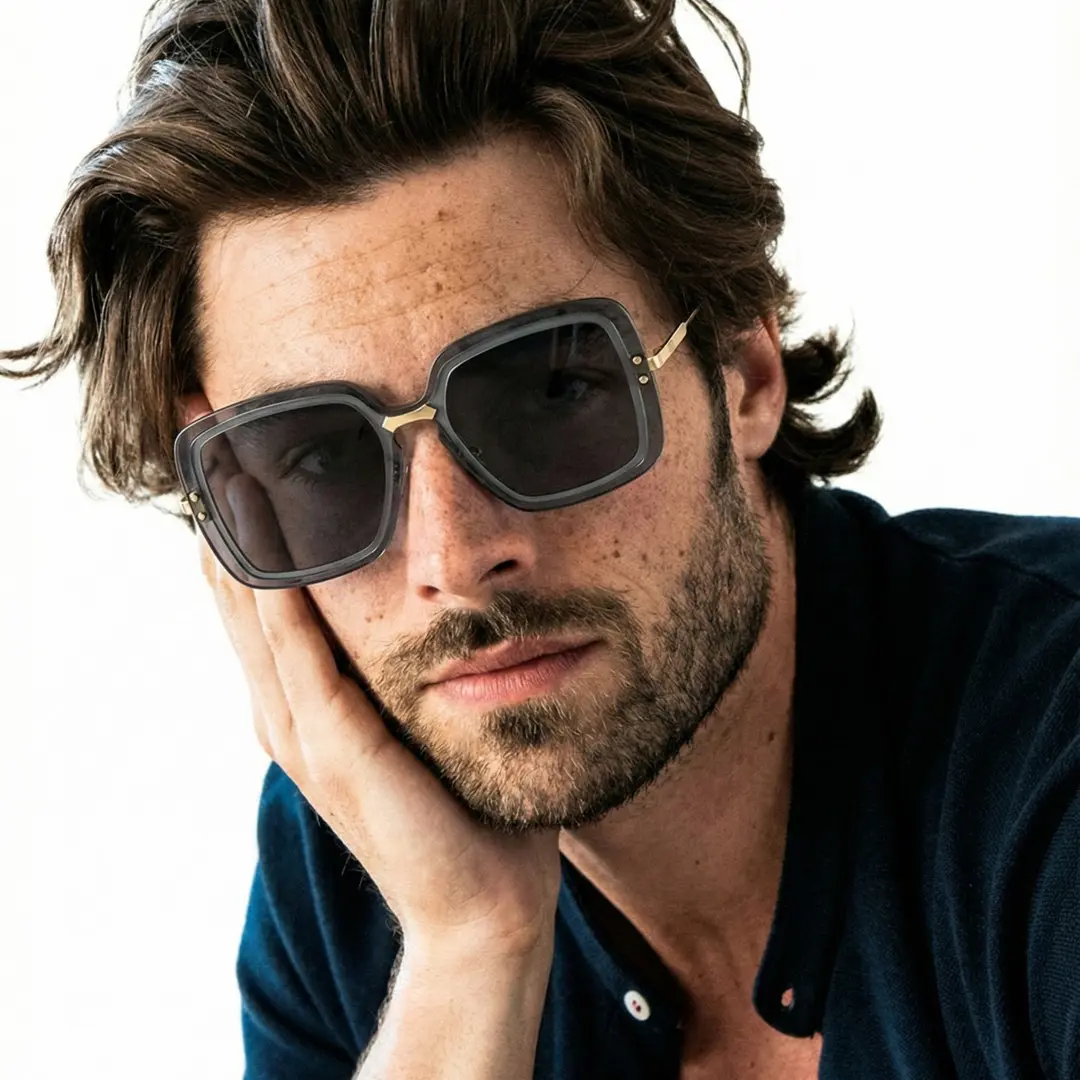 Front view of male wearing black square sunglasses, hand near face, natural expression, SX0372508