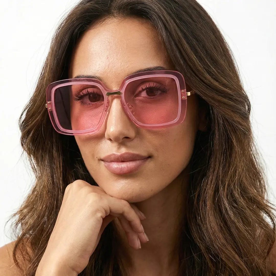 Front view of female wearing pink square sunglasses, resting chin on hand, relaxed expression, SX0372508