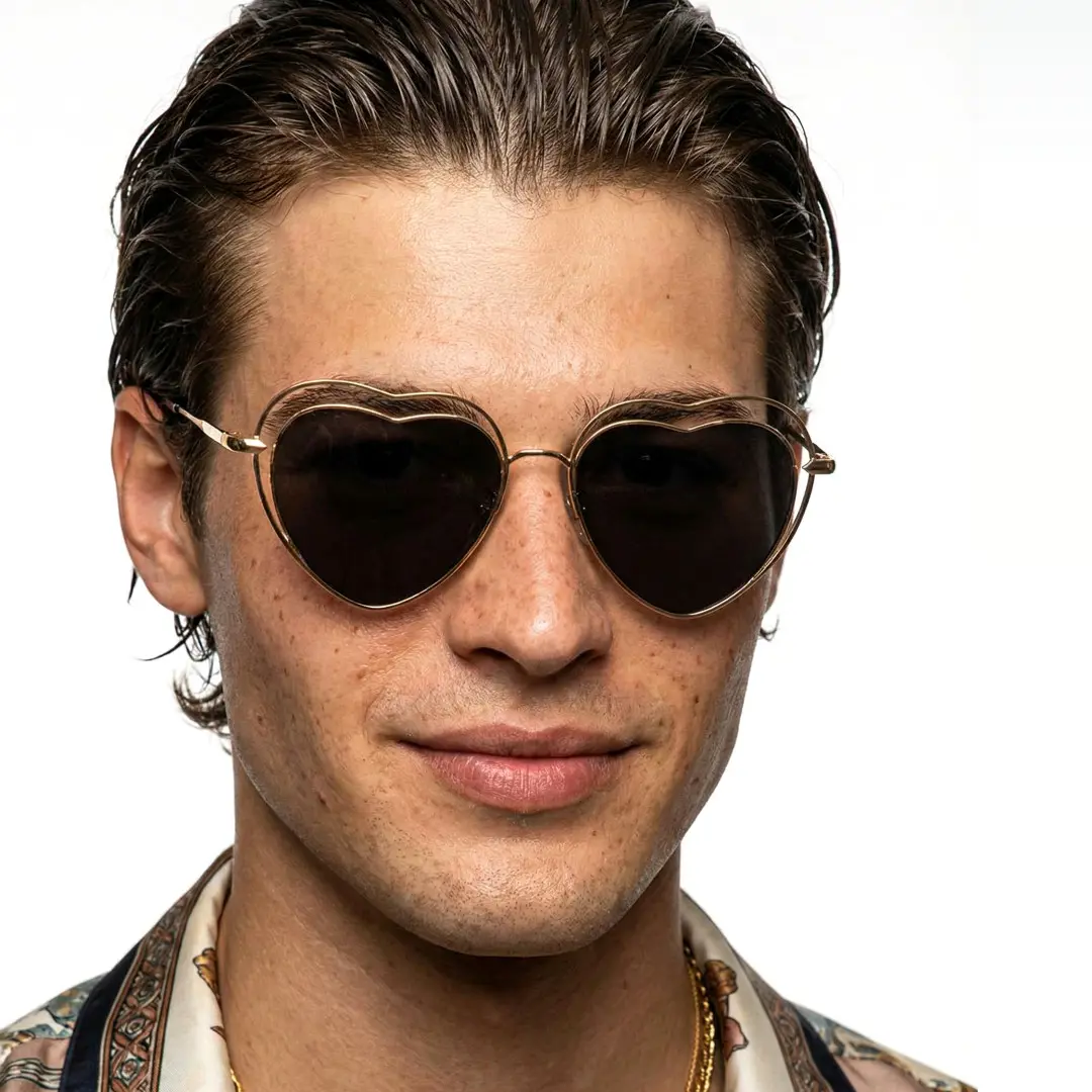 Close-up view of male wearing black heart sunglasses, neutral expression, UM0082506