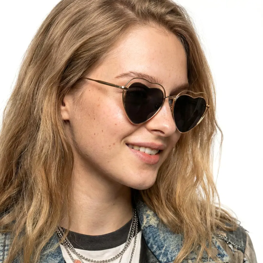 Profile view of female wearing black heart sunglasses, smiling, UM0082506