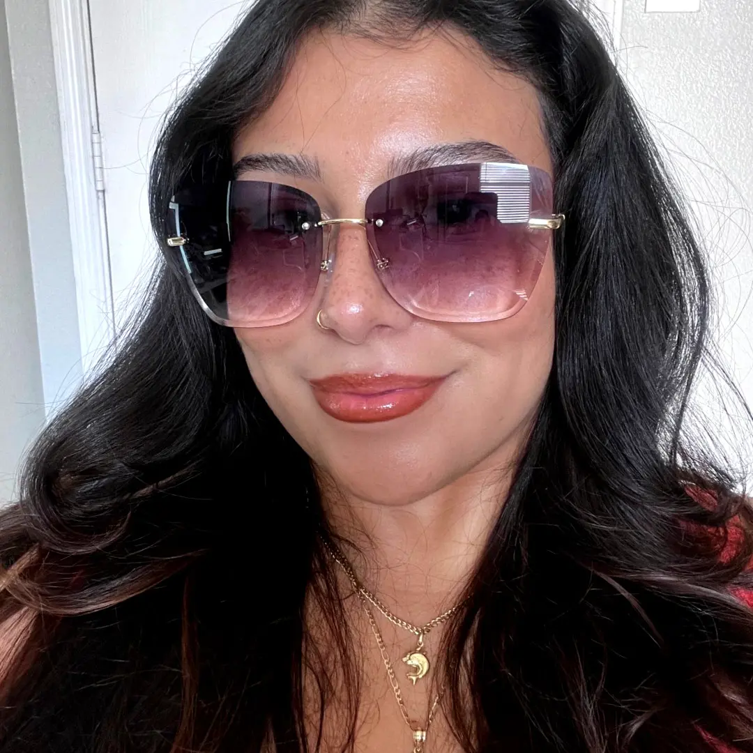 Close-up view of female wearing gray cat eye sunglasses, natural smile, CX0102505